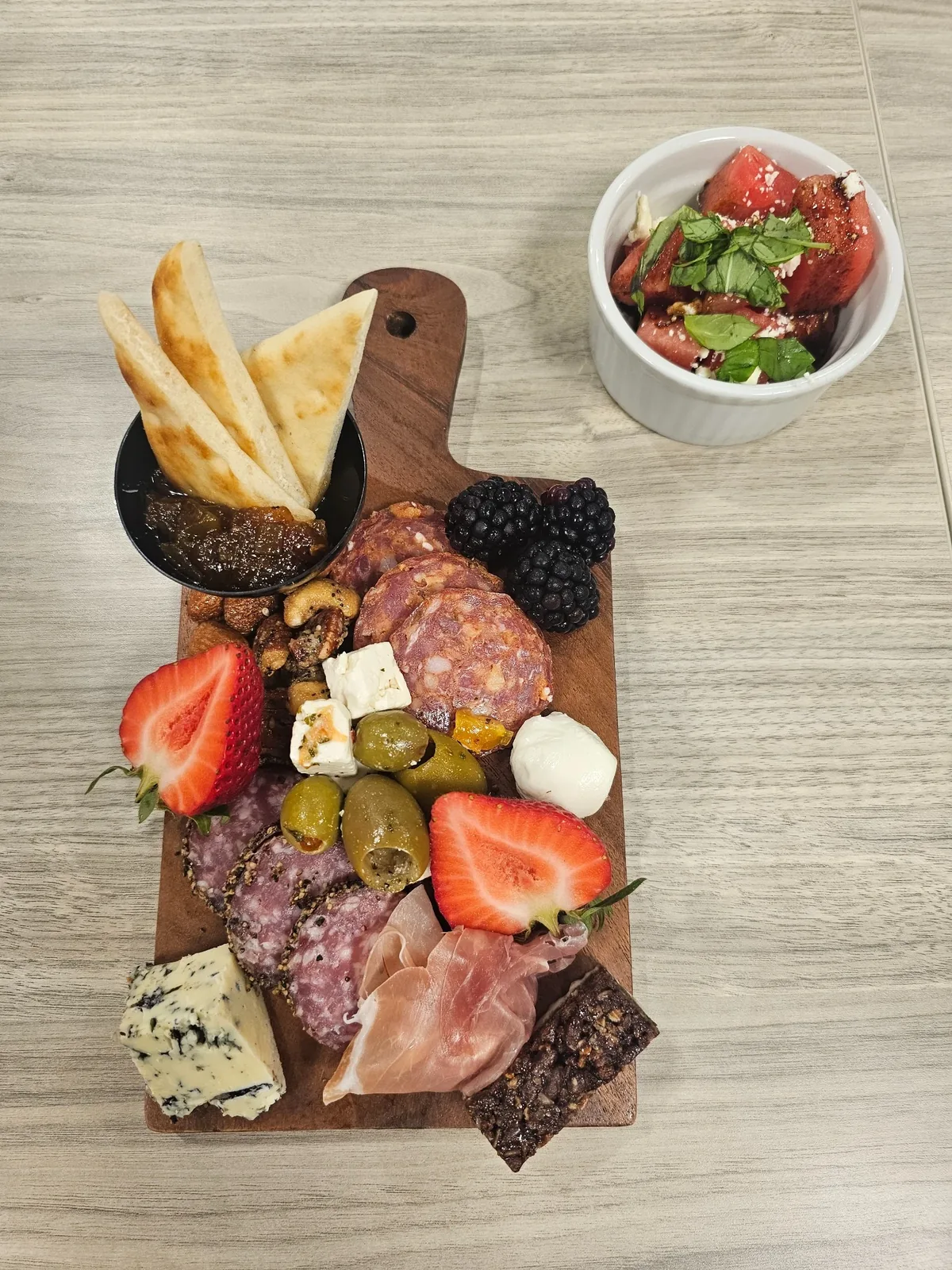 Individual charcuterie board paired with a watermelon cup for an intimate gathering
